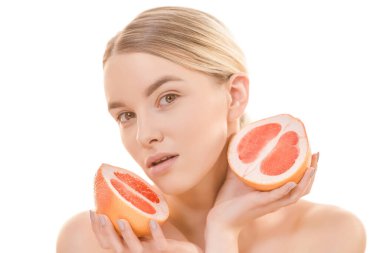 Beyaz arka planda greyfurt tutan tatlı kadın.