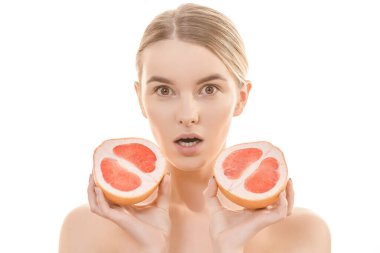 Beyaz arka planda greyfurt tutan tatlı kadın.