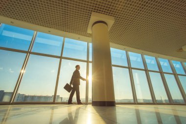 Ofiste elinde bavulla yürüyen adam.