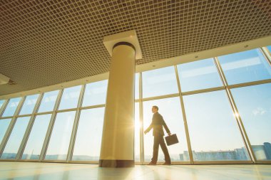 Ofiste elinde bavulla yürüyen adam.