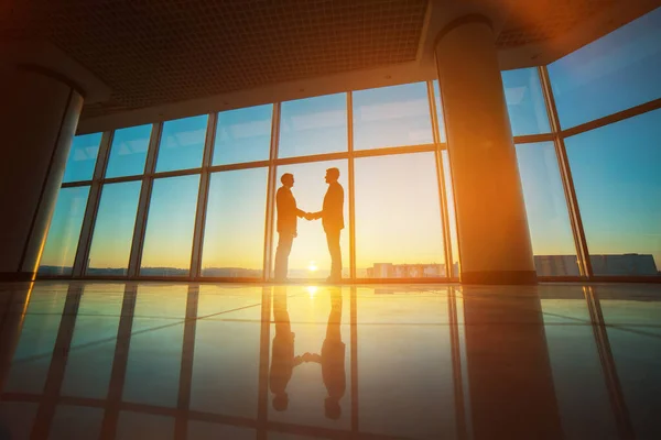Kaksi Liikemiestä Kättelee Toimistossa Kirkkaalla Auringon Taustalla — kuvapankkivalokuva