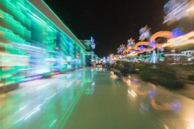 Parlak ışıkların arka planındaki renk sokağı. Akşam vakti.