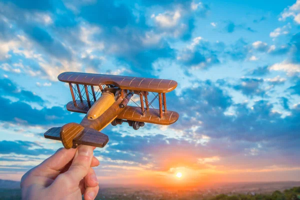 Χέρι Ένα Αεροπλάνο Παιχνίδι Στο Φόντο Του Ηλιοβασιλέματος — Φωτογραφία Αρχείου
