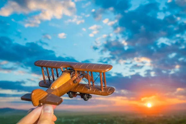 Χέρι Ένα Αεροπλάνο Παιχνίδι Στο Φόντο Του Ηλιοβασιλέματος — Φωτογραφία Αρχείου