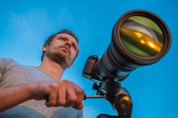 Mies Työskentelee Kameran Kanssa Sinistä Taustaa Vasten — kuvapankkivalokuva