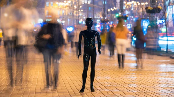 The mannequin standing on the crowd street. evening time