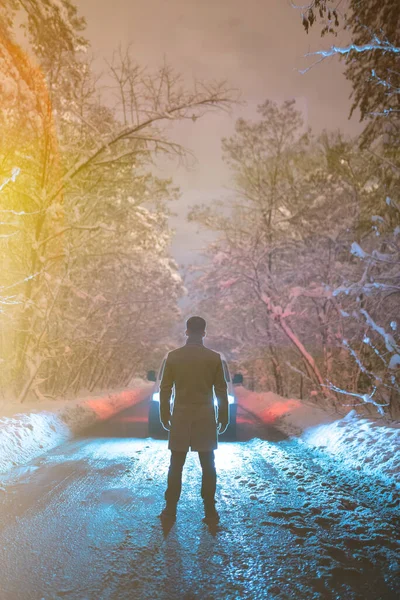 Mies Seisoo Autoa Vasten Lumisella Tiellä Ilta Aika — kuvapankkivalokuva