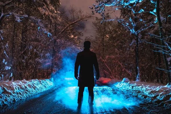 Mies Seisoo Sinisen Savun Lähellä Talvimetsässä Ilta Aika — kuvapankkivalokuva