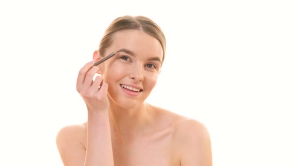 Hermosa Mujer Que Aplica Maquillaje Cara Sobre Fondo Blanco — Vídeo de stock