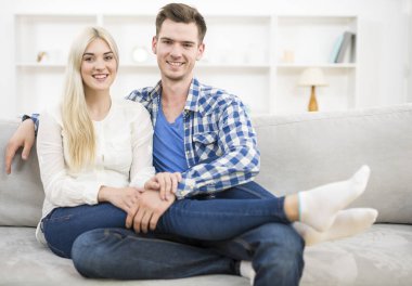 Gülümseyen çift kanepede dinleniyor.