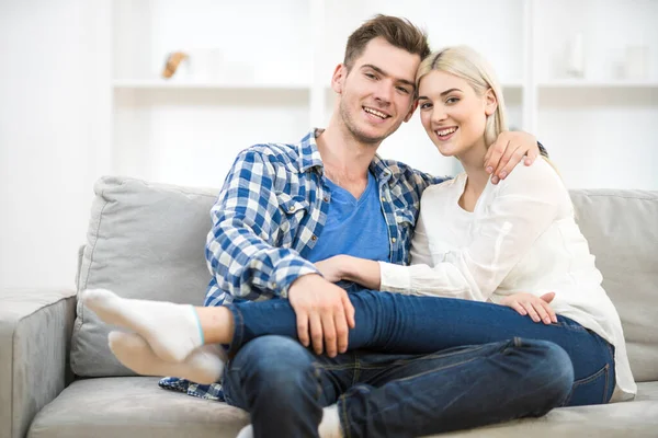 The happy man and woman sit on the sofa