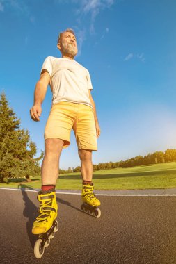 Yolda duran tekerlekli sandalyedeki yaşlı adam.