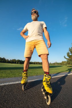 Asfalt üzerinde duran yaşlı adam.