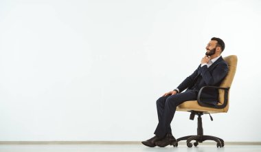 Beyaz arka planda ofis sandalyesinde oturan mutlu adam.