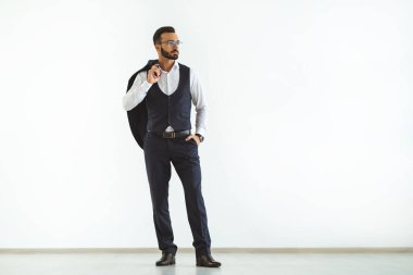 Beyaz arka planda duran gözlüklü iş adamı.