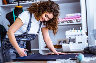 Güzel kadın masaya dikiş dikiyor.