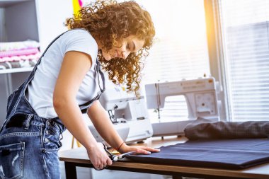 Güzel kadın masaya dikiş dikiyor.