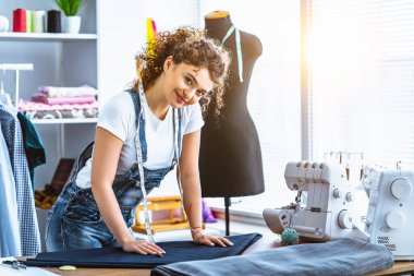 Dikiş makinesinin yanında çalışan mutlu terzi.