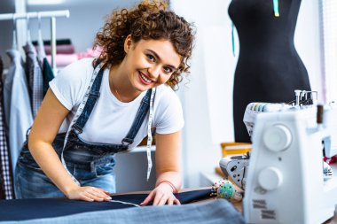 Dikiş makinesinin yanında çalışan genç terzi.