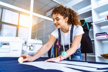 Mutlu terzi masaya bir elbise dikiyor.