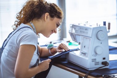 Dikiş makinesiyle çalışan mutlu terzi.