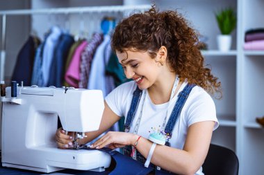 Dikiş makinesiyle çalışan mutlu terzi.