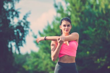 Sporcu kadın ağacın arka planında duruyor.