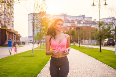 Konutlarda koşan sporcu kadın.
