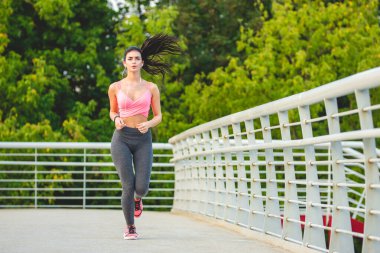 Köprüde koşan sporcu kadın.