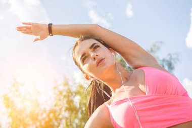 Güneş ışığı fırınında gerinen sporcu kadın.