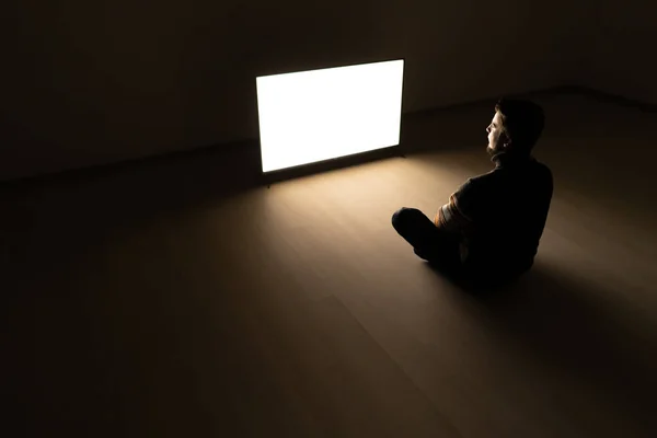 Człowiek Siedzący Ciemnym Pokoju Przed Telewizorem — Zdjęcie stockowe