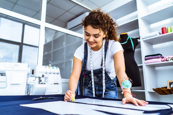 Mutlu terzi masaya bir elbise dikiyor.