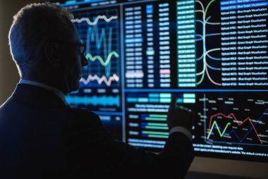 Yaşlı işadamı büyük sensör ekranı üzerinde çalışıyor.