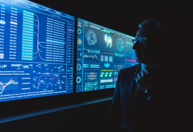 Karanlık odada mavi ekranın yanında duran adam.