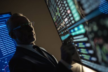 Yaşlı işadamı büyük sensör ekranı üzerinde çalışıyor.