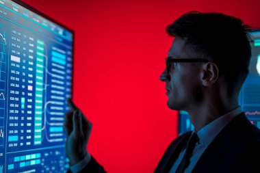 Takım elbiseli adam mavi sensör monitörüne dokunuyor. 