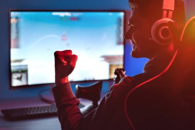Kişisel bilgisayarında video oyunları oynayan kulaklıklı adam.
