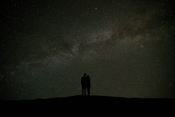 The couple standing on the sky with stars background