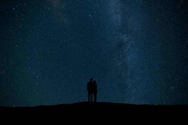Pariskunta Seisoo Tähtitaivaan Taustalla — kuvapankkivalokuva