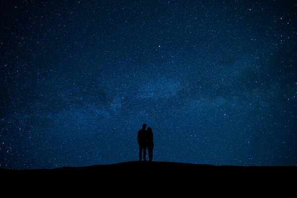The man and woman standing on the sky with stars background
