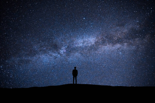 The man standing on the picturesque starry sky background