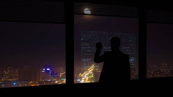 在夜景背景下的虚拟屏幕上工作的商人 — 图库照片