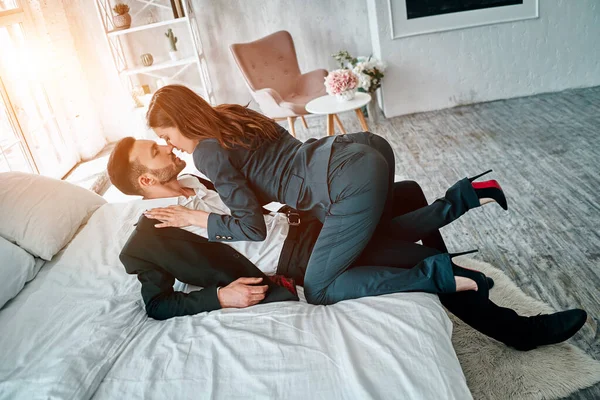 The business woman and man kissing on the bed