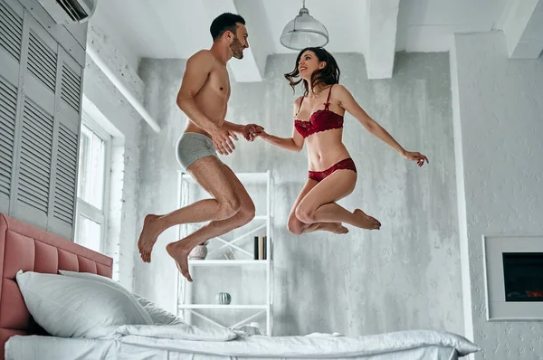 Homem Feliz Mulher Cueca Pulando Cama — Fotografia de Stock