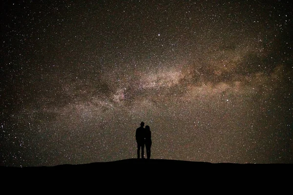 Paret Som Står Den Pittoreske Stjernehimmelen Bakgrunnen stockfoto