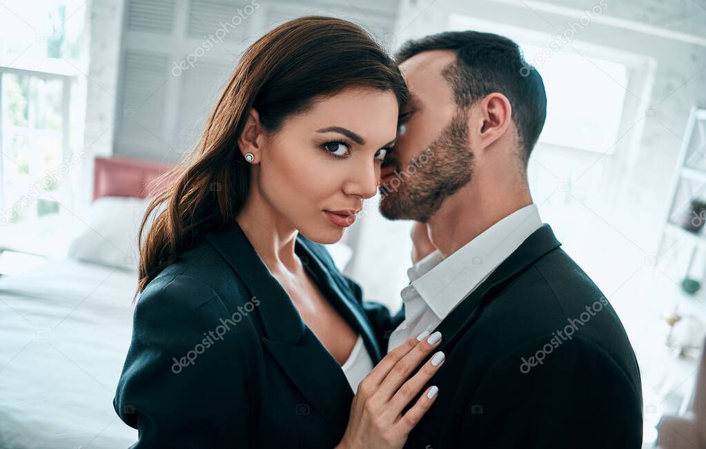 The woman and man in suits hug in the room