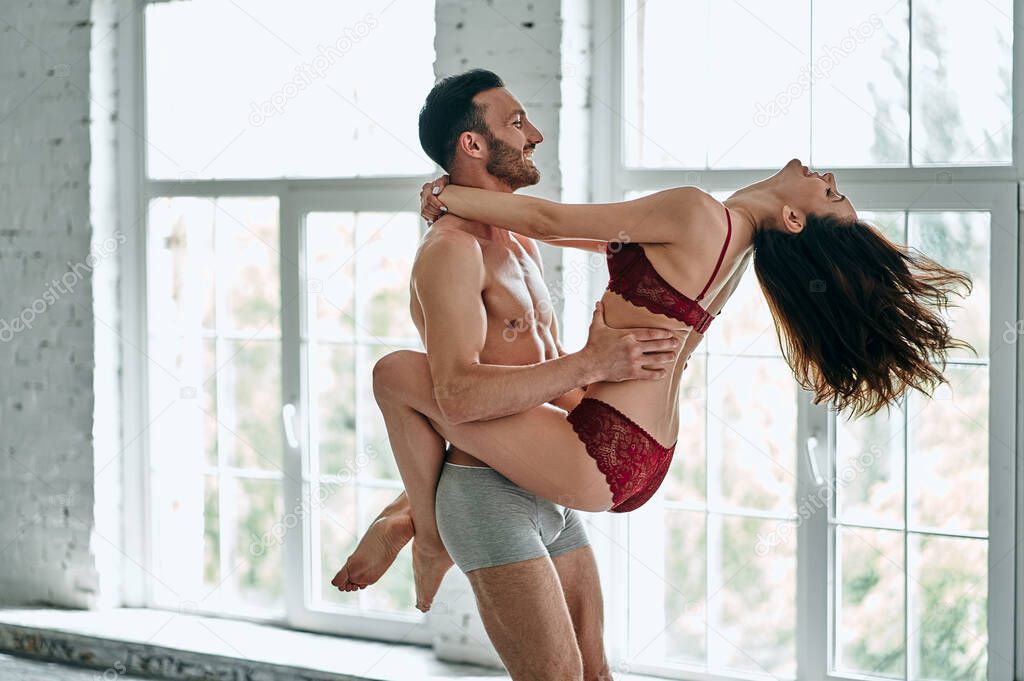 The happy man playing with a sexy woman in underwear