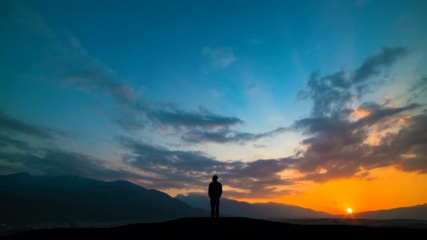 Hombre Pie Una Montaña Contra Una Puesta Sol Con Luz — Vídeos de Stock