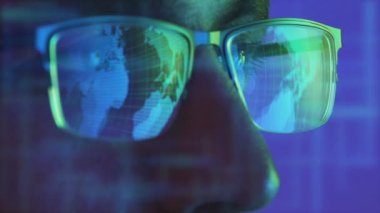 Hologram arkaplanındaki görüntüye bakan gözlüklü bir erkeğin yüzü.