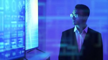 Hologram arka planında büyük bir ekranın yanında duran adam